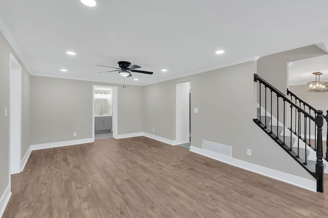 interior space featuring light hardwood / wood-style floors, crown molding, and ceiling fan with notable chandelier