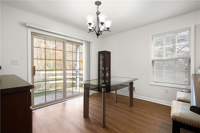 office area with a wealth of natural light, dark hardwood / wood-style floors, and a notable chandelier