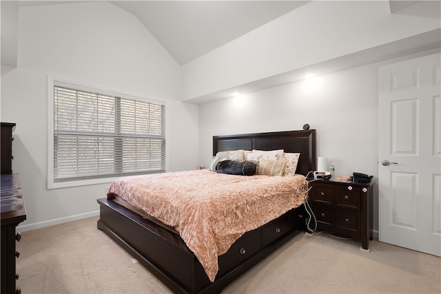 bedroom featuring lofted ceiling and light carpet