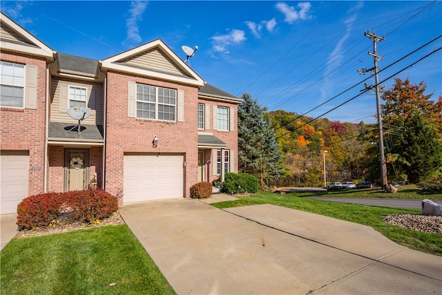 multi unit property featuring a garage and a front lawn