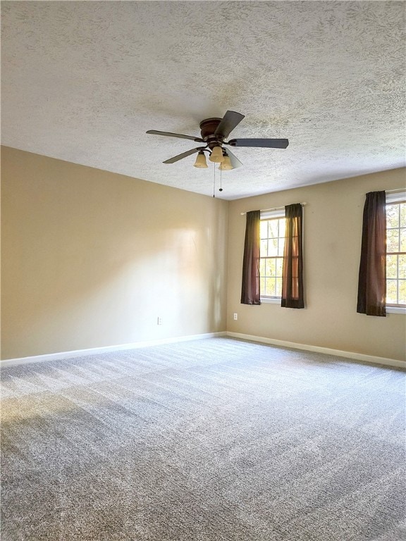 unfurnished room featuring carpet floors, a textured ceiling, plenty of natural light, and ceiling fan