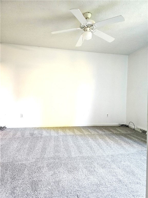 carpeted spare room with a textured ceiling and ceiling fan