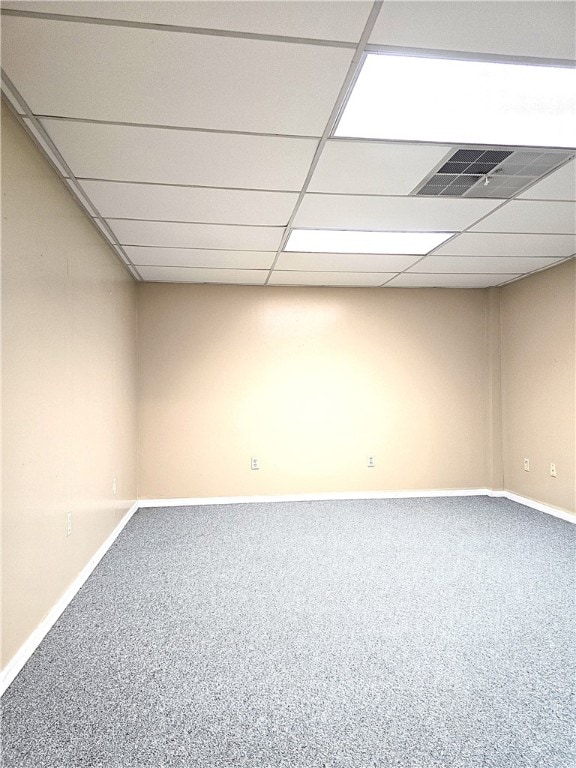 basement with a paneled ceiling and carpet floors