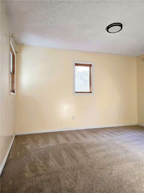 carpeted empty room with a textured ceiling