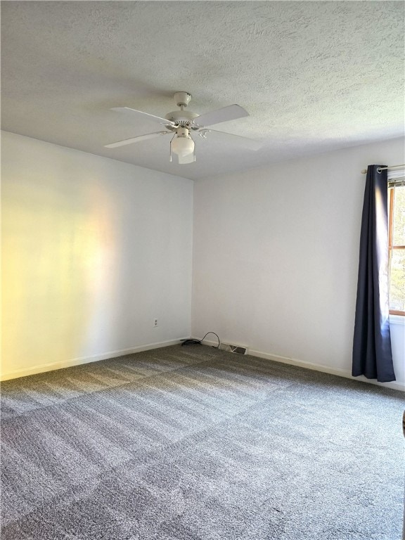 carpeted empty room featuring ceiling fan and a textured ceiling