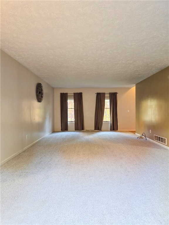 carpeted empty room featuring a textured ceiling