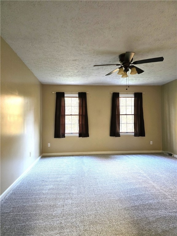 unfurnished room featuring ceiling fan, a textured ceiling, and plenty of natural light