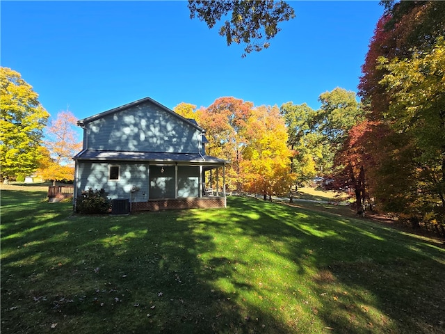 rear view of house with a yard and central AC