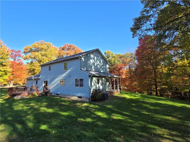 back of property with a yard and a wooden deck