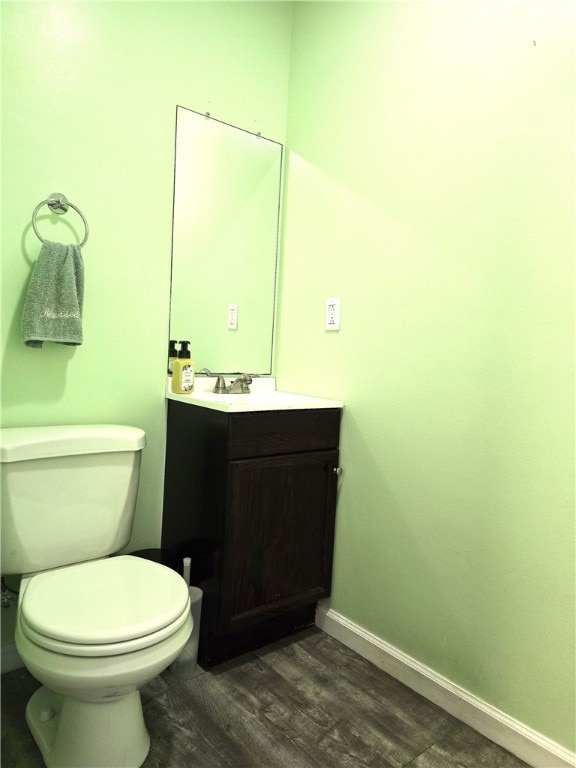 bathroom with vanity, toilet, and wood-type flooring