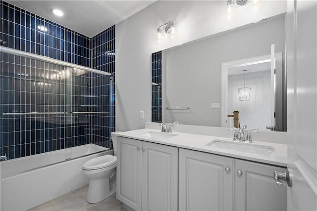 full bathroom with tile patterned floors, toilet, combined bath / shower with glass door, and vanity