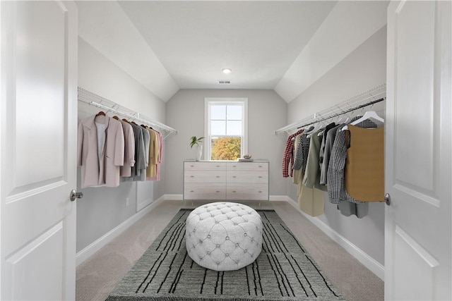 walk in closet featuring light colored carpet and lofted ceiling