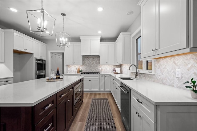 kitchen with sink, hanging light fixtures, stainless steel appliances, dark brown cabinets, and white cabinets