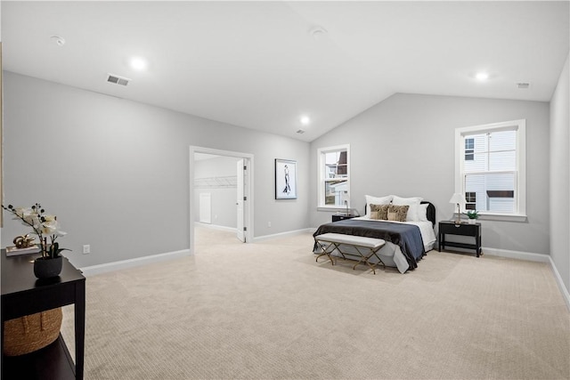 bedroom featuring lofted ceiling, light colored carpet, and a spacious closet