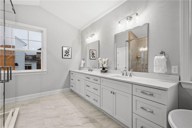 bathroom with vanity, a shower with shower door, and vaulted ceiling