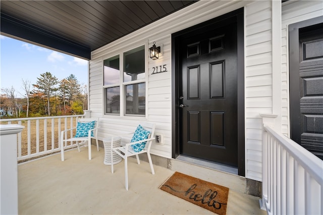 view of exterior entry featuring covered porch