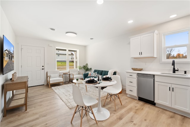 kitchen featuring sink, light hardwood / wood-style floors, dishwasher, and white cabinets