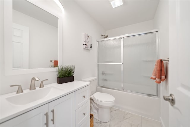 full bathroom with vanity, bath / shower combo with glass door, and toilet