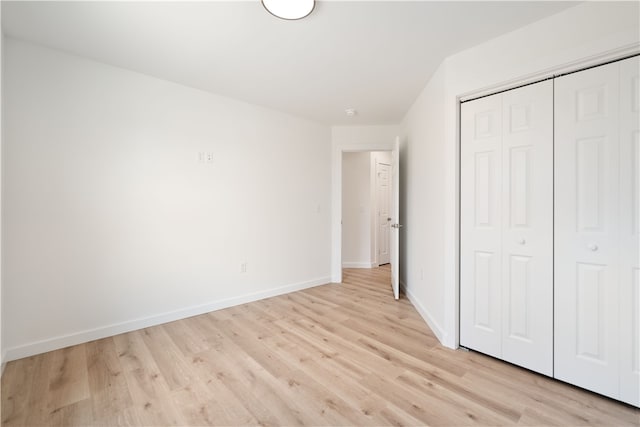 unfurnished bedroom featuring a closet and light wood-type flooring