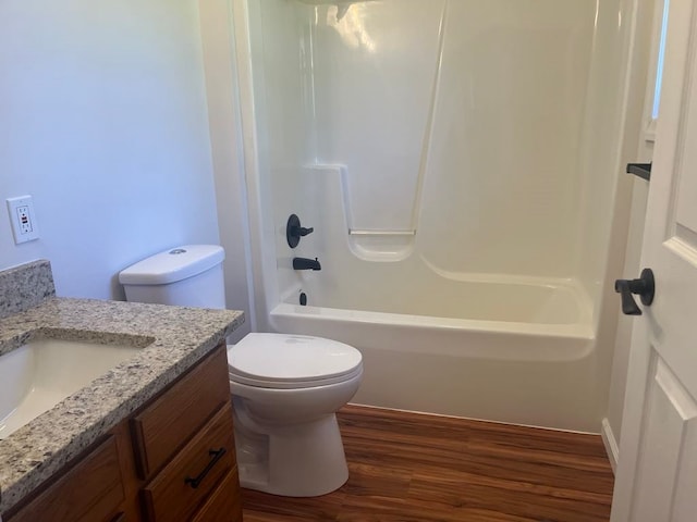 full bathroom featuring toilet, hardwood / wood-style flooring, vanity, and washtub / shower combination