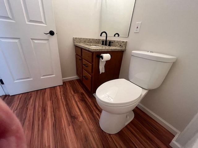 bathroom with vanity, toilet, and wood-type flooring