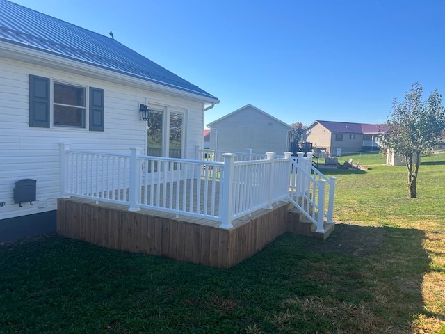 exterior space featuring a wooden deck and a lawn