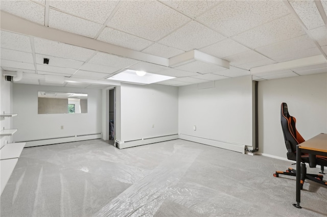 basement with light carpet, a drop ceiling, and baseboard heating