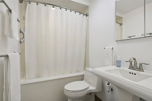 full bathroom featuring toilet, shower / bathtub combination with curtain, and sink