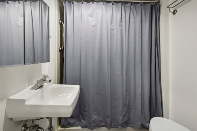 bathroom with sink, a shower with curtain, and toilet