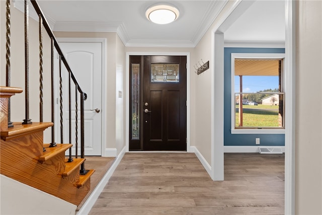 foyer featuring ornamental molding and light hardwood / wood-style flooring