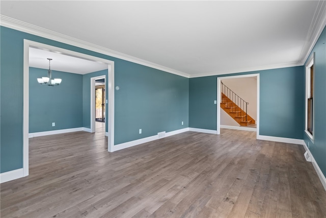 unfurnished living room featuring ornamental molding, a notable chandelier, and hardwood / wood-style flooring