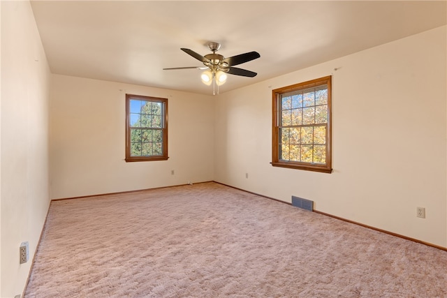 carpeted empty room featuring ceiling fan and plenty of natural light