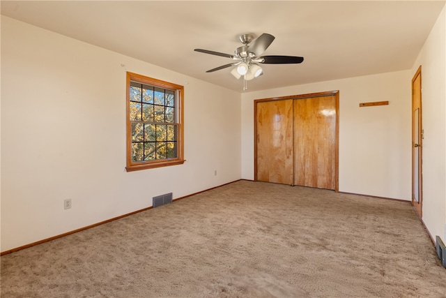 unfurnished bedroom with carpet floors, a closet, and ceiling fan