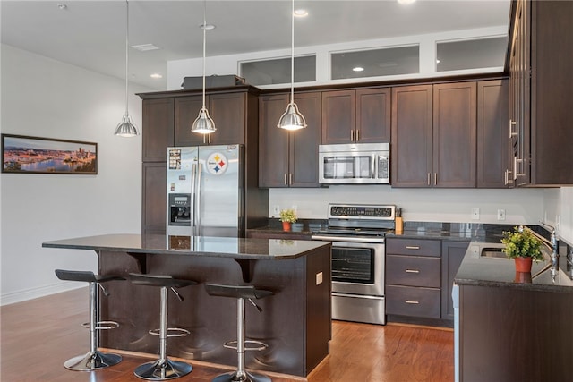 kitchen featuring stainless steel appliances, pendant lighting, and a kitchen island