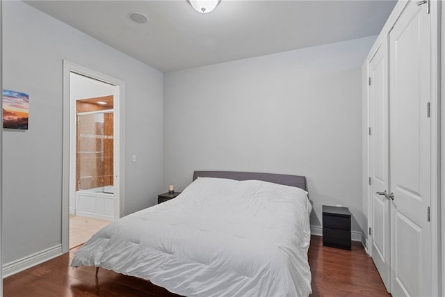 bedroom with dark hardwood / wood-style floors and connected bathroom