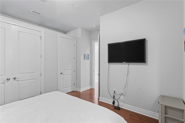 bedroom featuring dark wood-type flooring and a closet