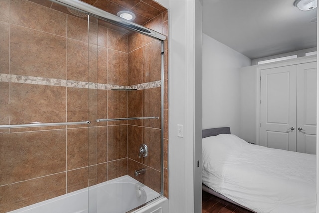 bathroom featuring enclosed tub / shower combo and hardwood / wood-style floors