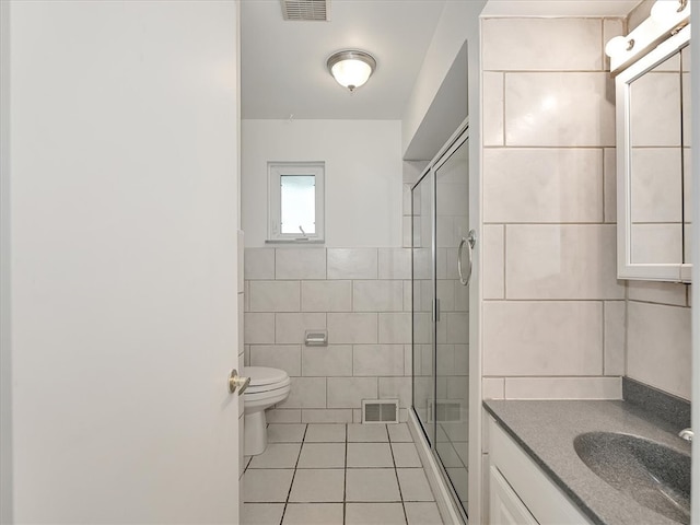 bathroom with walk in shower, tile walls, toilet, vanity, and tile patterned floors