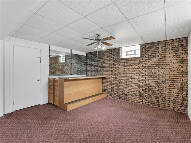 bar with brick wall, a drop ceiling, carpet flooring, and ceiling fan