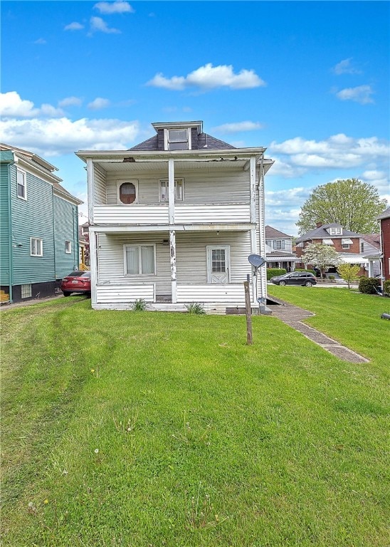 rear view of house featuring a yard