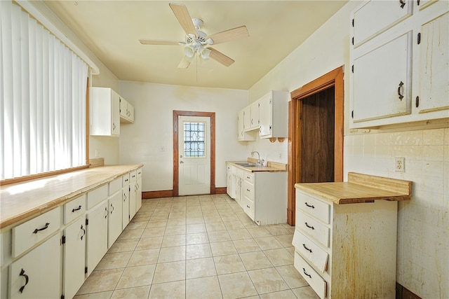 kitchen with sink, white cabinetry, light tile patterned flooring, and ceiling fan