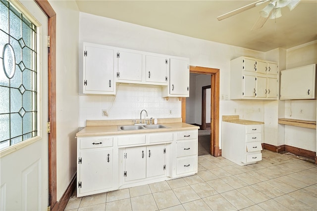 kitchen with white cabinets, sink, backsplash, and a wealth of natural light