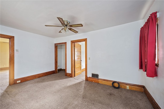 spare room with ceiling fan and carpet