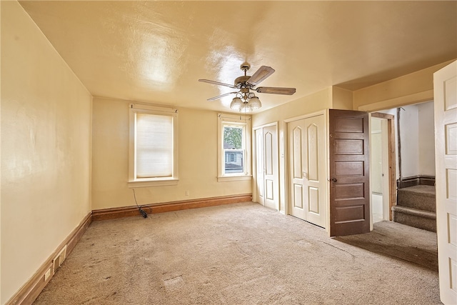 carpeted empty room featuring ceiling fan