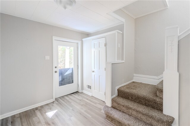 entryway featuring crown molding and light wood-type flooring