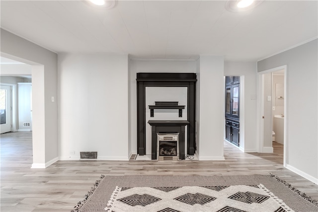 unfurnished living room featuring light hardwood / wood-style floors and ornamental molding