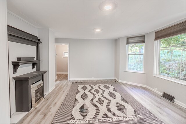 unfurnished living room with a fireplace and light wood-type flooring