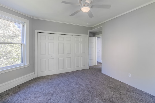 unfurnished bedroom featuring a closet, ornamental molding, carpet, and ceiling fan