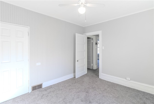 unfurnished bedroom with crown molding, carpet flooring, and ceiling fan