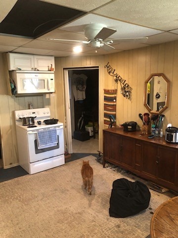 kitchen with dark brown cabinetry, light colored carpet, ceiling fan, and white appliances